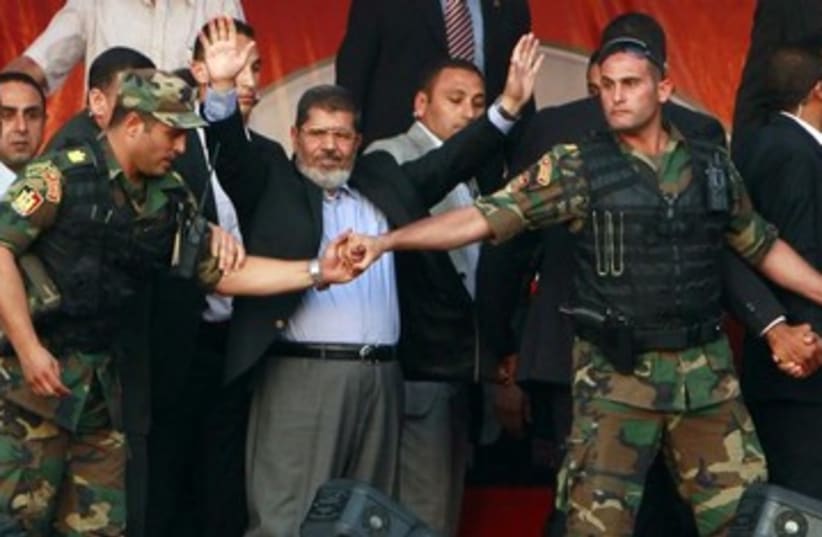 Egyptian President Morsi surrounded by guards 370 (photo credit: REUTERS)