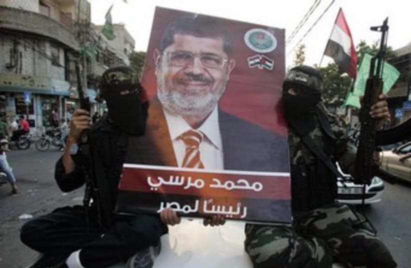 Hamas gunmen hold Morsi poster 370 (photo credit: Mohammed Salem/Reuters)