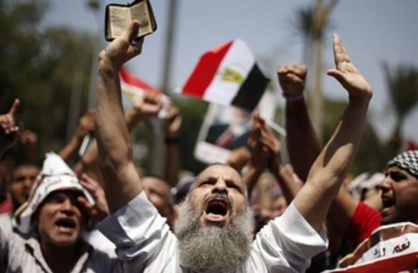 Morsi supporter yelling arms up July 5, 2013 370 (photo credit: REUTERS/Suhaib Salem)