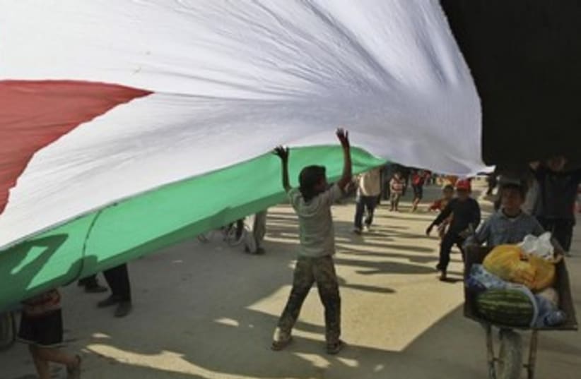 Syrian refugees hold a large Syrian opposition flag 370 (photo credit: REUTERS/Muhammad Hamed )