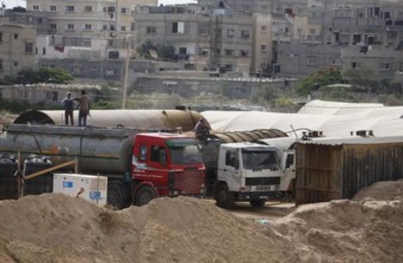 Palestinians fill tankers with fuel on the Egypt border370 (photo credit: Reuters)