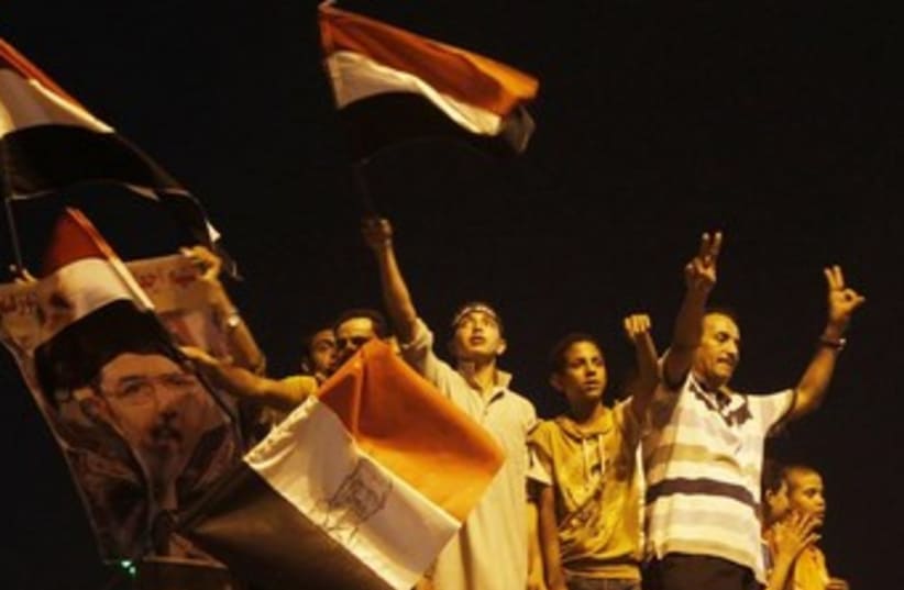 muslim brotherhood supporters wave flag at night 370 (photo credit: REUTERS)