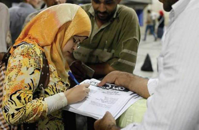 A woman signs petition in support of the anti-Morsi movement (photo credit: ASMAA WAGUIH / REUTERS)
