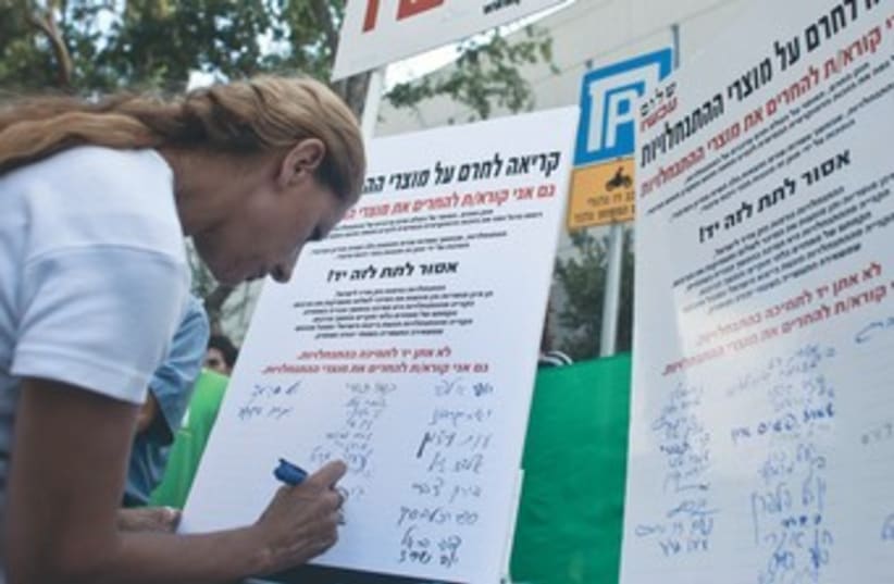 Woman signs Peace Now petition against settlements 370 (photo credit: Reuters)
