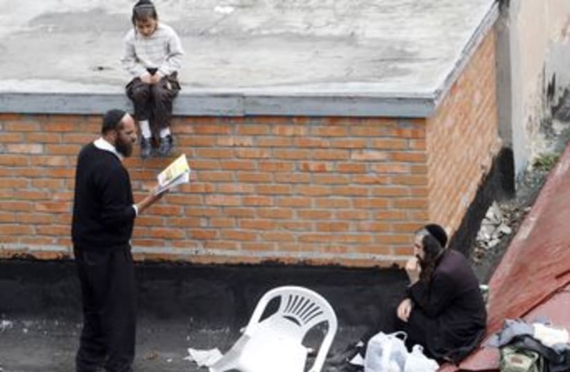 Haredim pray on the roof of the building in Uman 370 (photo credit: REUTERS)