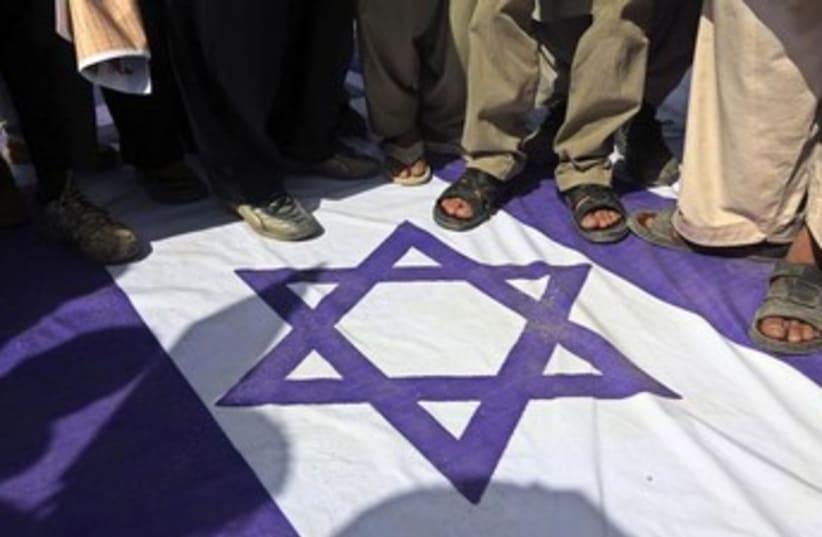 Stepping on Israeli flag 370 (photo credit: REUTERS/Omar Sobhani )