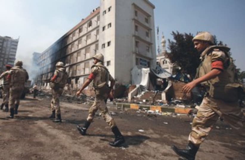 Egypt soldiers walk passed burnt building 370 (photo credit: REUTERS)