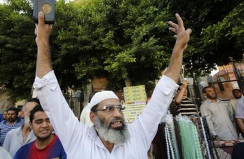Muslim protester raises arms 370 (photo credit: REUTERS)