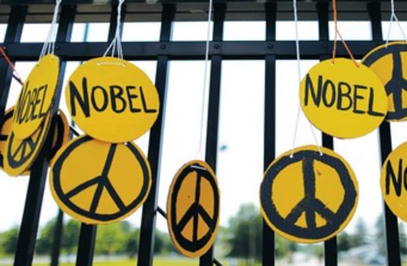 PEACE SYMBOLS adorn a fence. 370 (photo credit: REUTERS)