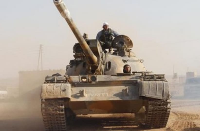 Free Syrian Army fighter drives a tank 370 (photo credit: Reuters)