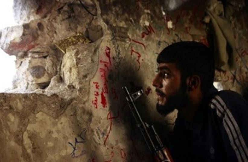 A Free Syrian Army fighter sits on a lookout  370 (photo credit: REUTERS)