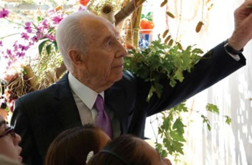 Shimon Peres decorating Succa370 (photo credit: Mark Neiman/GPO)