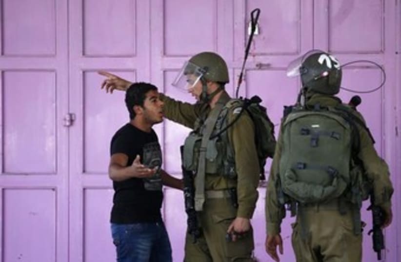 idf soldier and palestinian argue 370 (photo credit: REUTERS)