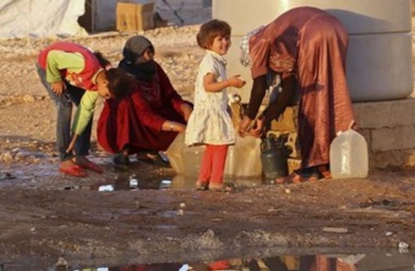 Syrian refugees collect water 370 (photo credit: REUTERS)