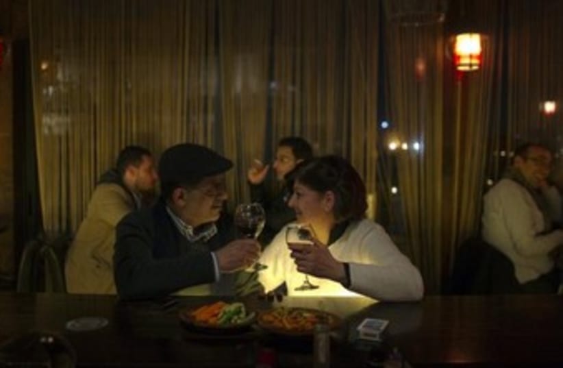 A Palestinian couple sits at a bar 370 (photo credit: Reuters)