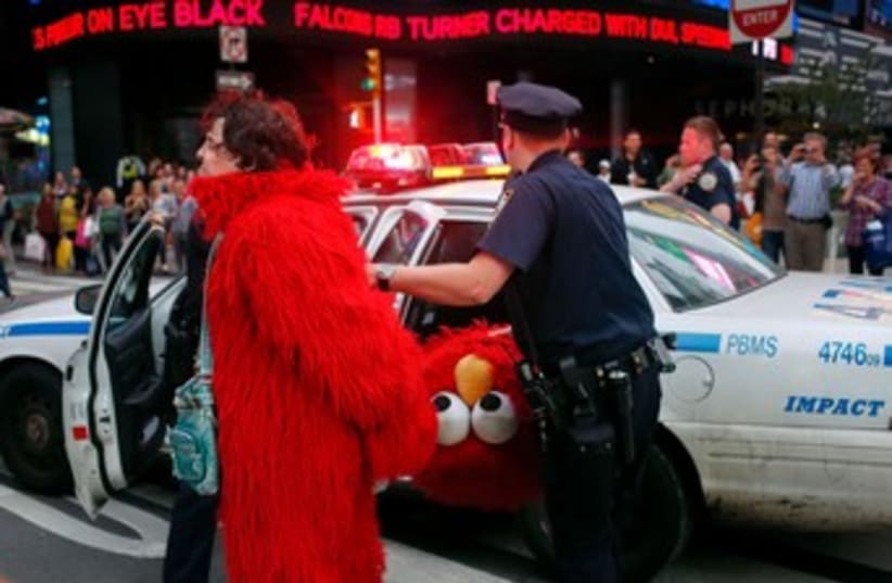 Dan Sandler, dressed as Elmo, is handcuffed and detained 370 (photo credit: reuters)