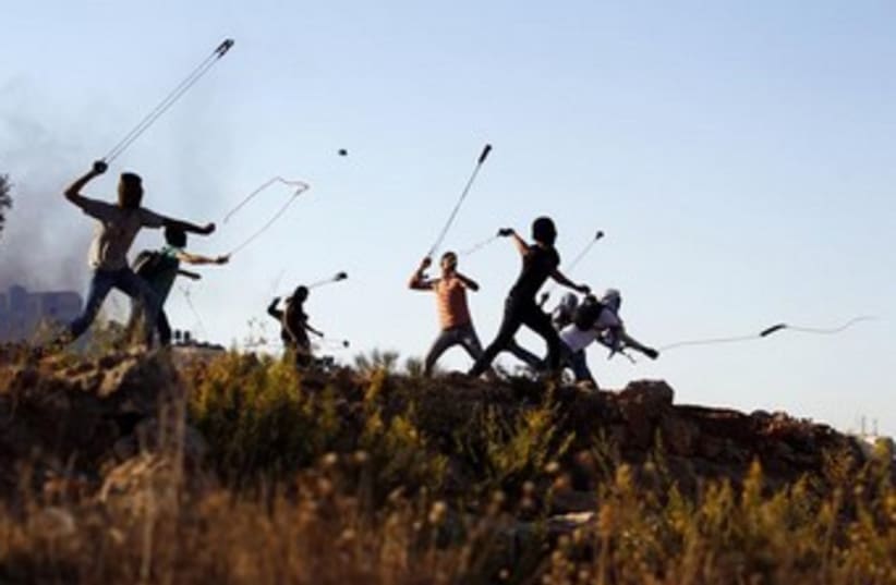 Palestinians hurl slingshots at IDF troops 370 (photo credit: REUTERS)