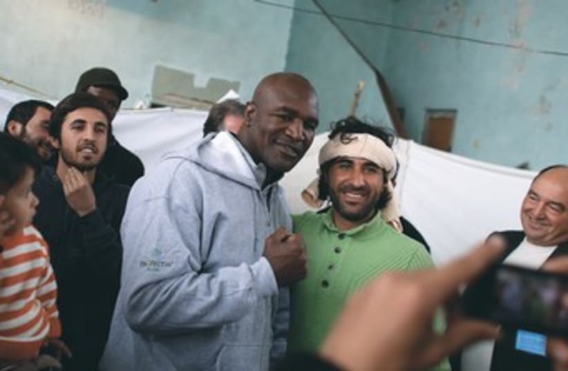 Retired boxer Evander Holyfield with Syrian refugees 370 (photo credit: Stoyan Nenov/Reuters)