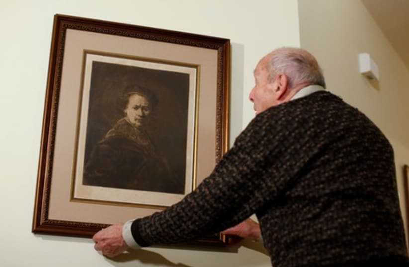 Ettlinger adjusts his print of Rembrandt self-portrait 370 (photo credit: REUTERS)