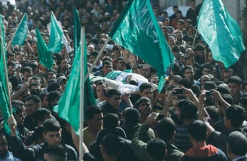 A crowd waves Hamas flags during an Islamist's funeral 370 (photo credit: REUTERS)