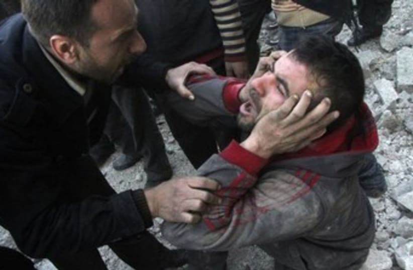 A Syrian man reacts after an air raid in Aleppo 370 (photo credit: Reuters)