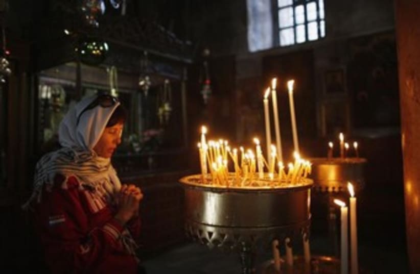 Woman prays at Church of Nativity, Bethlehem. (photo credit: Reuters)