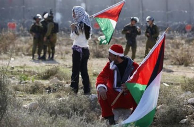 Palestinian protesters in Santa suits in Bilin protests (photo credit: REUTERS/Mohamad Torokman)