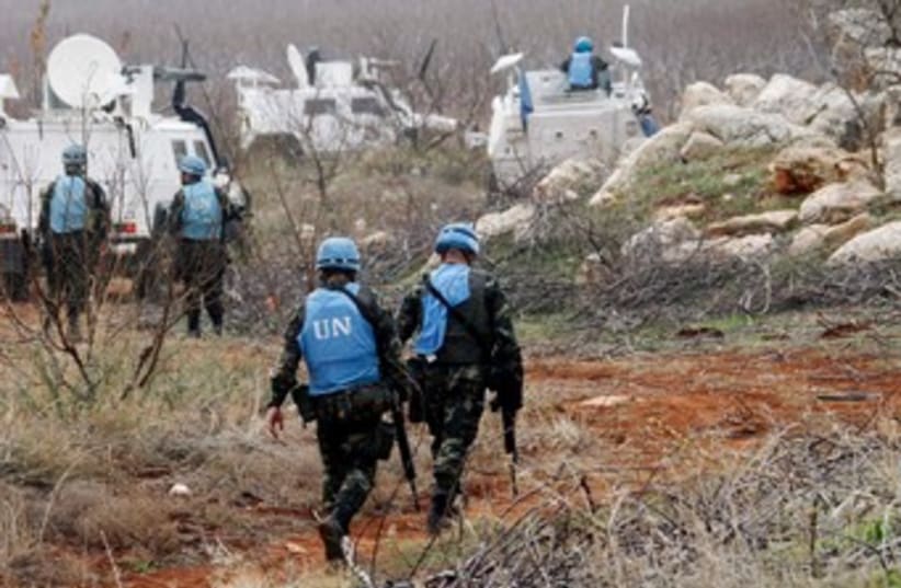 UNIFIL troops inspect remains of shell launched from Lebanon (photo credit: REUTERS/Ali Hashisho)