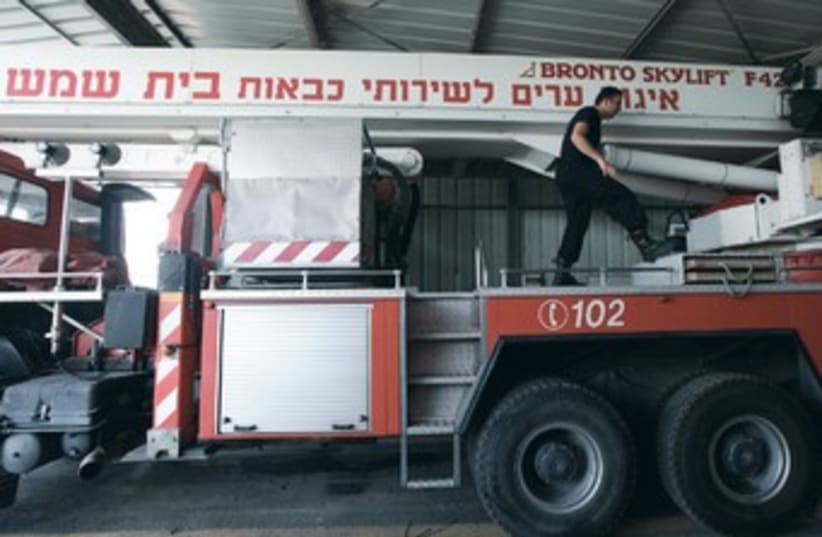 A fireman prepares equipment in Beit Shemesh. (photo credit: Marc Israel Sellem/The Jerusalem Post)