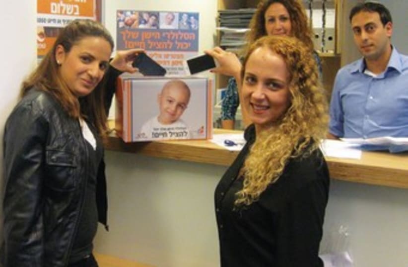 Good samaritans drop their old cellphones in a collection box at United Mizrahi Bank. (photo credit: Courtesy)