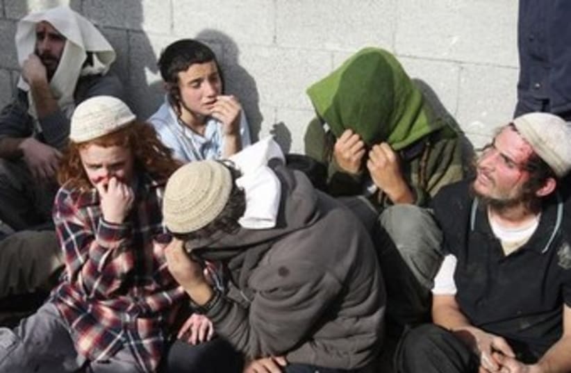 Jewish settlers sit together after being detained by Palestinians, January 7, 2014.  (photo credit: Reuters)