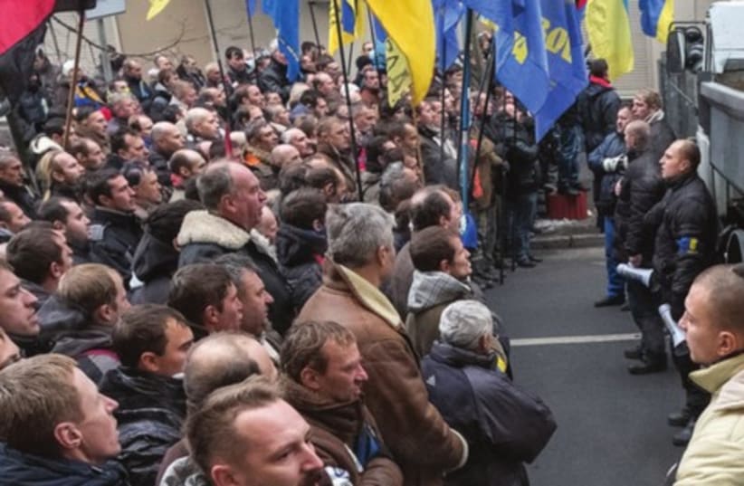 Ukrainian Interior Ministry personnel block pro-EU demonstrators near the Ministry of Internal Affairs in Kiev, December 20 (photo credit: GLEB GARANICH / REUTERS)