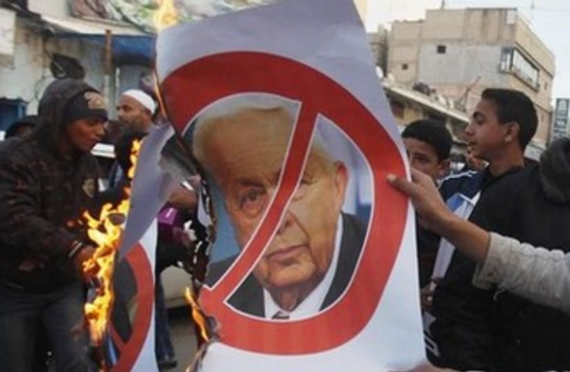 Palestinians celebrate the passing of late former Israeli Prime Minister Ariel Sharon Khan Younis, southern Gaza Strip. (photo credit:  REUTERS/Ibraheem Abu Mustafa)