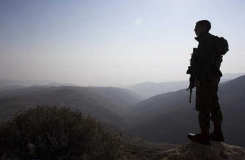 IDF soldier looking over Jordan Valley. (photo credit: REUTERS/Ronen Zvulun)