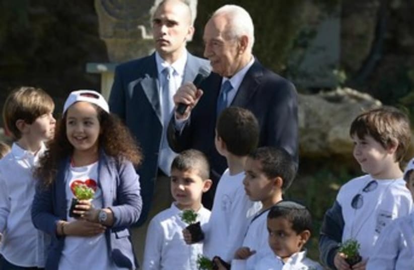 President Shimon Peres planting trees for Tu Bishvat with children at the President's Residence in Jerusalem, January 15, 2014. (photo credit: Mark Neiman/GPO)