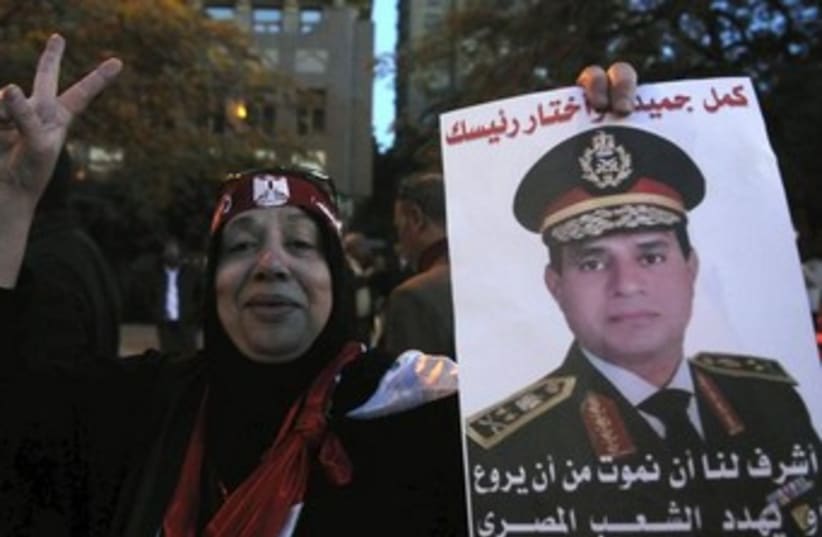 An Egyptian woman holds up a picture of army general Abdel al-Sisi (photo credit: REUTERS)
