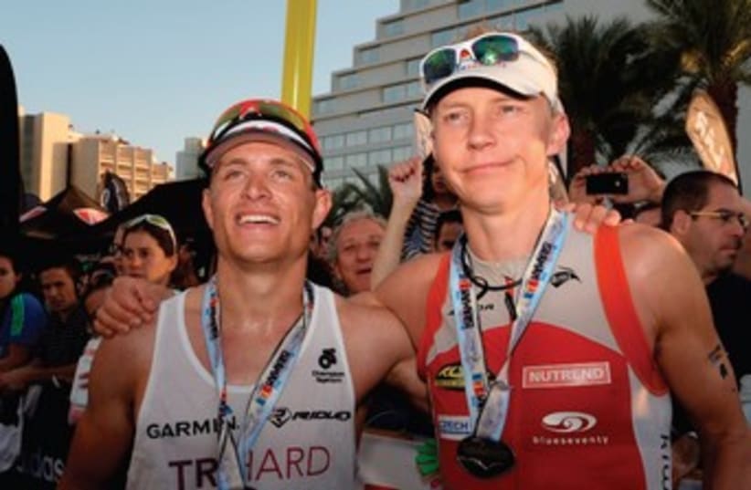 Petr Vabrousek (right) defended his Israman Ironman full distance title in Eilat on Friday, with Israel’s Tom Mamarelli (left) finishing in second place overall. (photo credit: AMIT SHISEL)