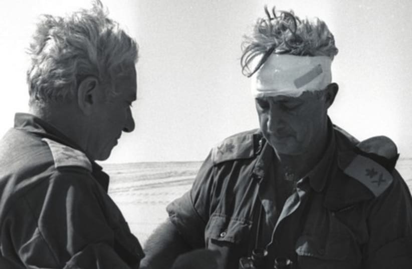Former Chief of Staﬀ Haim Bar-Lev consults with Maj. Gen. Ariel Sharon during the Yom Kippur War, 1973 (photo credit: YOSSI GREENBERG / GPO)