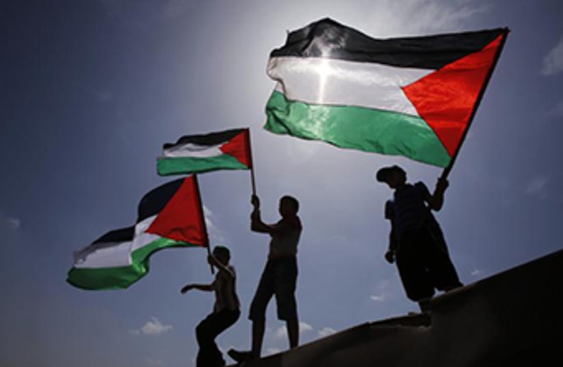 Palestinians wave PLO flags (photo credit: REUTERS)