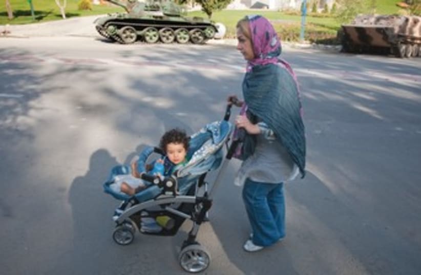 An Iranian woman strolls with her daughter in Tehran. (photo credit: REUTERS)