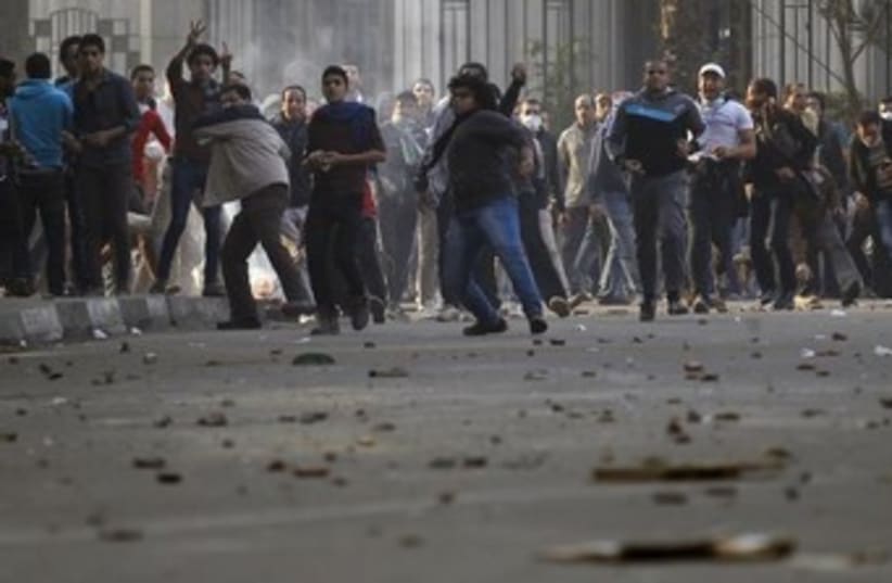 Muslim Brotherhood protesters throw stones and glasses during clashes with supporters of Egypt's army and police in Cairo, January 25, 2014. (photo credit: REUTERS)