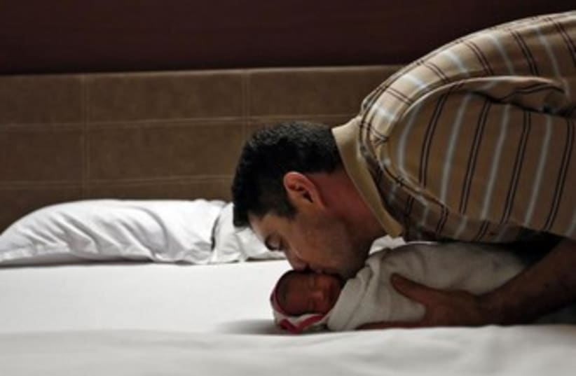 Man with baby born to surrogate mother. (photo credit: REUTERS)