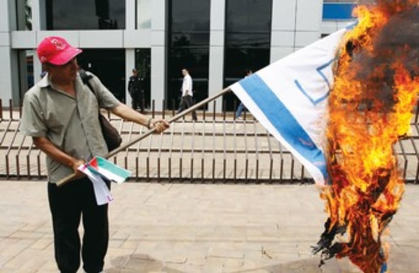 A European burns an Israeli flag. (photo credit: REUTERS)