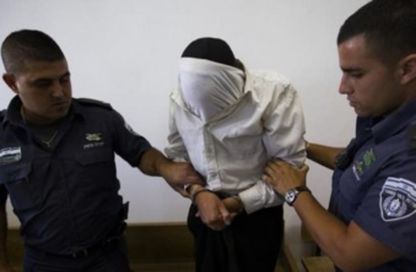 escorted by Israeli prison guards in the Jerusalem District Court (photo credit: REUTERS)