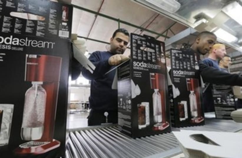 Employees pack boxes of the SodaStream product at the factory in the West Bank. (photo credit: REUTERS)