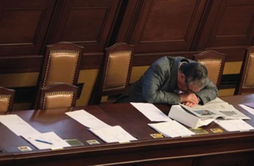 A man places his head on his desk in a fit of exhaustion. (photo credit: REUTERS)