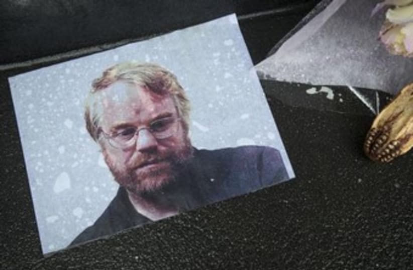 A photo of actor Philip Seymour Hoffman is pictured as part of a makeshift memorial in front of his apartment building in New York February 3, 2014.  (photo credit: REUTERS)