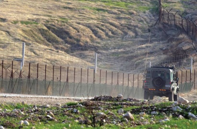 An Israel army vehicle patrols the Jordanian border in the Jordan Rift Valley, January 1 (photo credit: REUTERS)