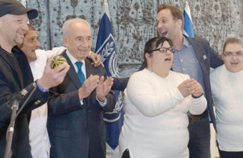 PRESIDENT SHIMON PERES poses with individuals with intellectual disabilities at his residence in the capital yesterday. (photo credit: COURTESY OF THE PRESIDENT'S RESIDENCE)