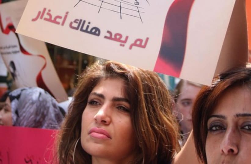 Women demonstrate against violence against women at the spot where Nancy Zaboun was murdered by her husband in the West Bank town of Bethlehem on July 31, 2012; the sign declares in Arabic, ‘Protecting women from violence is an official and social responsibility’ (photo credit: ISSAM RIMAWI / FLASH 90)